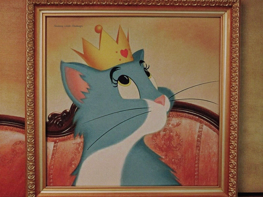 Kopfportrait einer Katze als gerahmte Leinwand ueber einem gemuetlichen Sofa