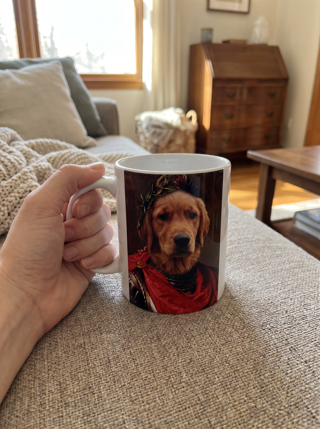 Hundetasse Römischer Kaiser in der Hand auf dem Sofa