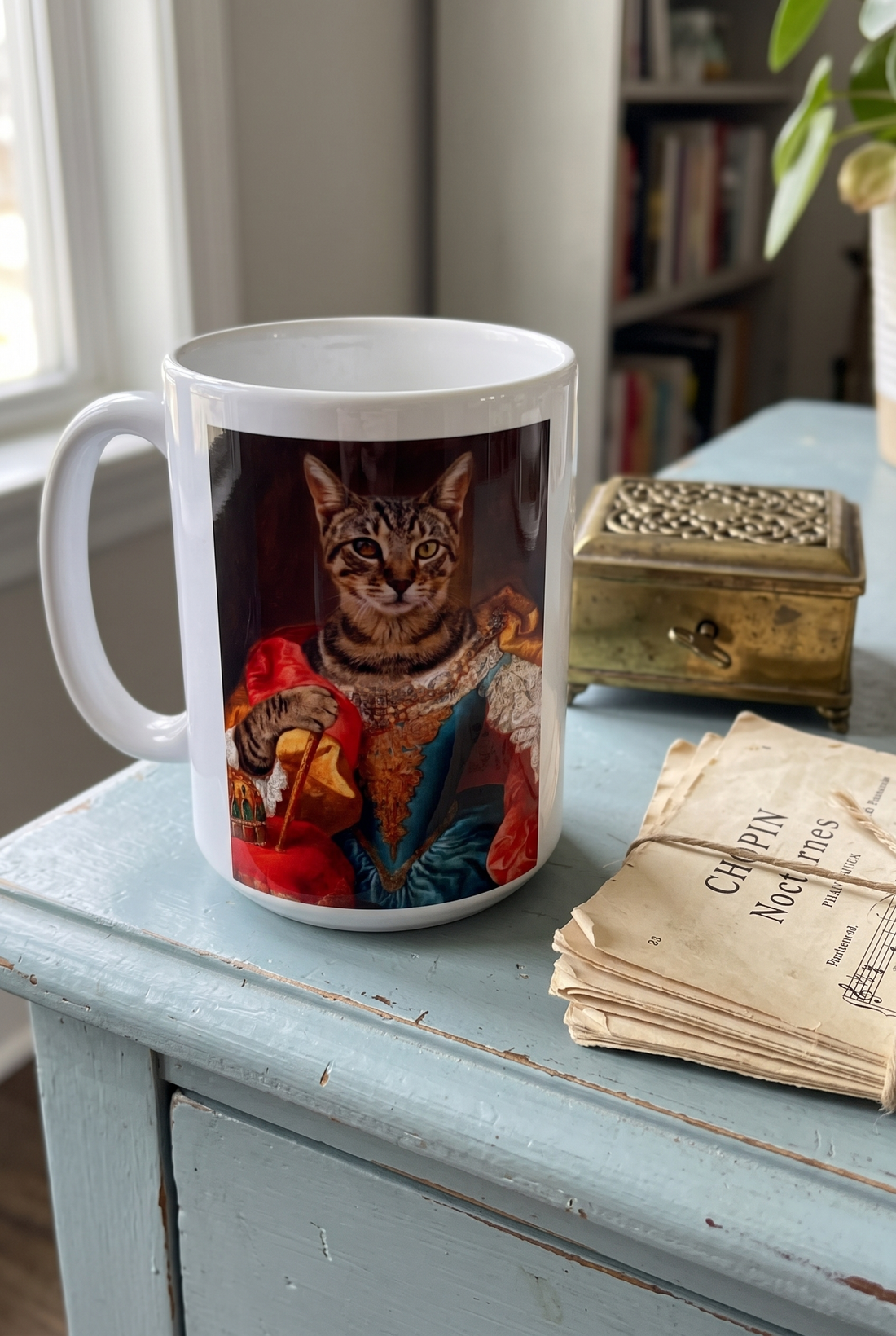 Personalisierte Tasse mit Katze im Barockstil auf einer hellblauen Anrichte mit Notenblaettern